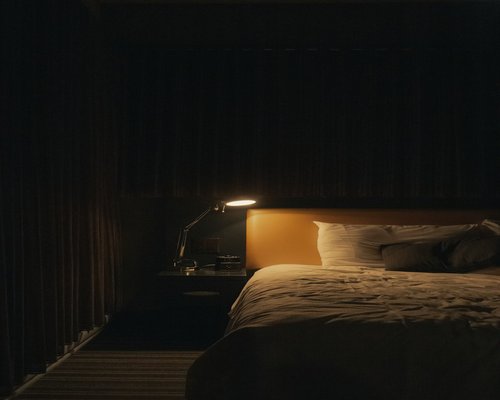 A cozy bedroom with warm lamp light indicating evening rest
